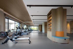 A gym with exercise equipment, large windows, and a modern design.