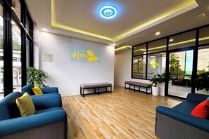 A modern interior with blue sofas, a wooden floor, and a bench. - KSK Serenity Resort (Puerto Princesa)