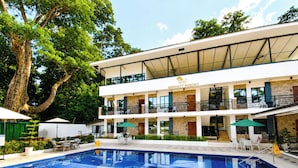 Un resort con piscina, mobiliario exterior y un edificio de dos plantas.