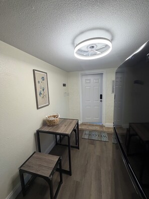 A hallway with a white door, a small table with a basket, and a doormat with 'WELCOME' written on it. - Loft Living: 4 to 5 minutes from Bush Gardens (Tampa)