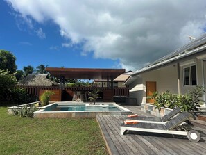 A backyard with a swimming pool, lounge chairs, and a wooden deck. - Villa Noa Vai • Swimming Pool & Lagoon Access by Kayak (papetoai)