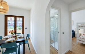 Eine moderne Wohnung mit Essbereich, einem Balkon mit Blick und einem Schlafzimmer mit Etagenbett.