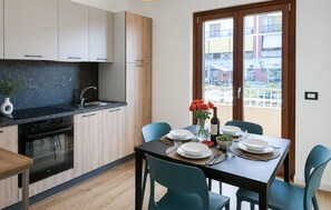 Eine moderne Küche mit Essbereich, Blick ins Freie und einem Tisch für zwei Personen.
