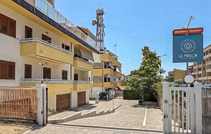 A residential building with multiple balconies, a gated entrance, and a sign indicating 'RESIDENCE 'HOLIDAY''. - Maison marina Suite - Mykonos (Paola)