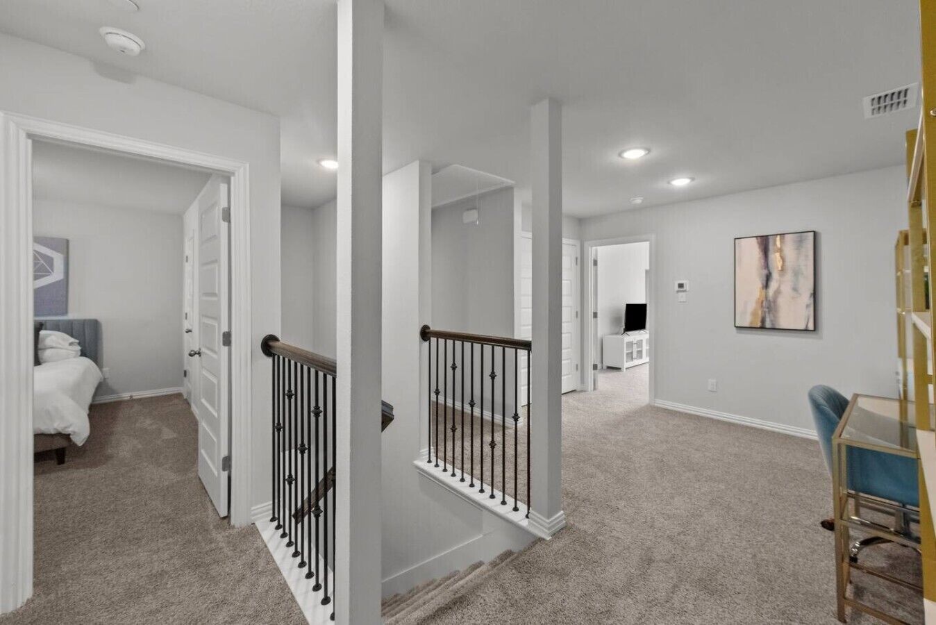 Un vaste espace de vie comprenant un escalier, un téléviseur à écran plat et un coin repas avec une table et des chaises.
