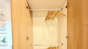 Ein Schrank aus Holz mit mehreren Einlegeböden und einer Kleiderstange.