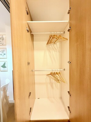 Ein Schrank aus Holz mit mehreren Einlegeböden und einer Kleiderstange.