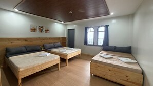 A room with two single beds, a wooden ceiling, and a window with curtains. - Inntayon Lodge Baguio City (Baguio)