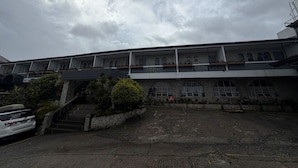 A multi-story building with a flat roof, multiple balconies, and a parking area in front. - Inntayon Lodge Baguio City (Baguio)