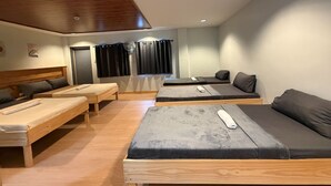 A modern, well-lit room with wooden furniture, including a bed, a sofa, and a bench. - Inntayon Lodge Baguio City (Baguio)