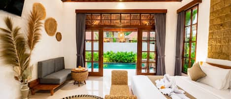 A modern interior with a wooden ceiling, a sofa, a bed, and a view of a swimming pool.