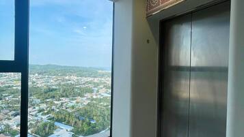 Ein Zimmer mit großem Fenster, einem Aufzug und einer gemusterten Decke.
