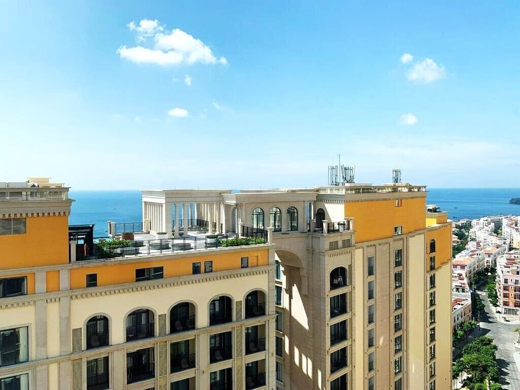 Ein Wolkenkratzerhotel mit mehreren Balkonen mit Blick auf eine Küstenstadt.