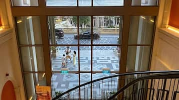 A view from a hotel window with a clear street view, including a fountain and buildings.