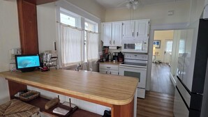 A kitchen with a wooden countertop, white cabinets, a refrigerator, and a stove. - Palm Trees & Great Sunsets! Exclusive Bayfront w/ Huge Outdoor Living Area&Docks (Stone Harbor)