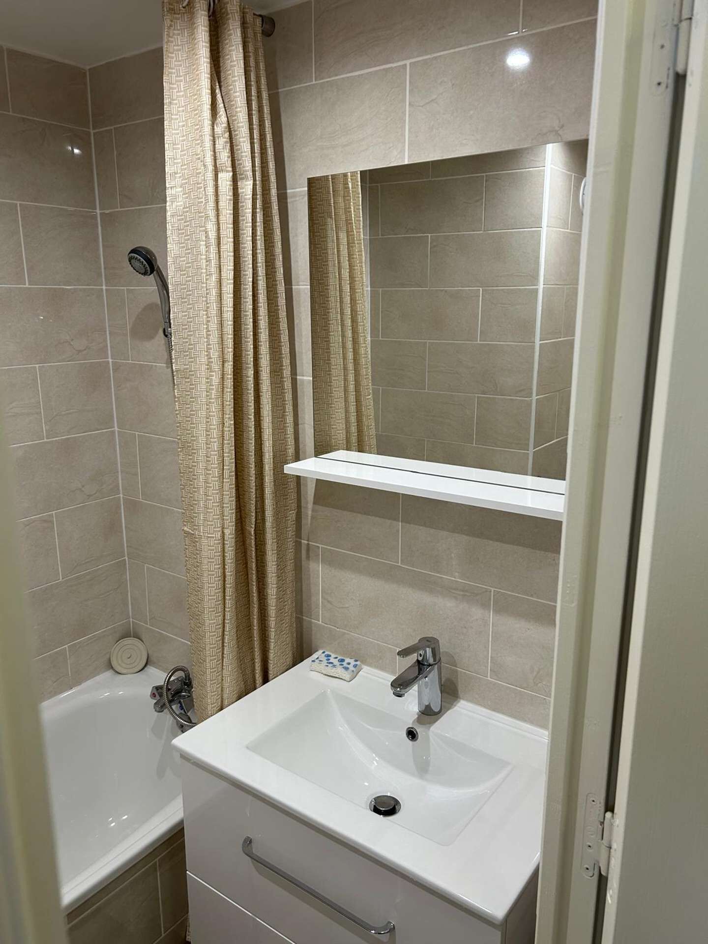Un baño con bañera, lavabo, espejo y ducha.