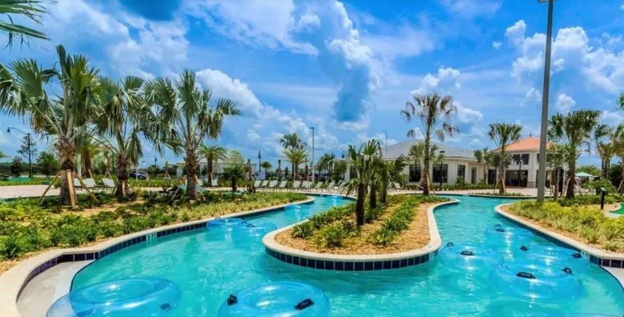Un espace piscine doté de plusieurs toboggans et bordé de palmiers.
