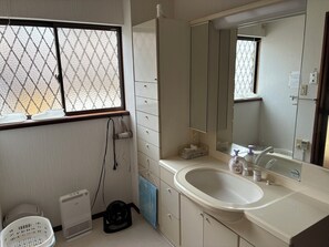 Ein Badezimmer mit Waschbecken, Spiegel und Fenster.