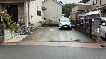A narrow street with a parked car and a bicycle.