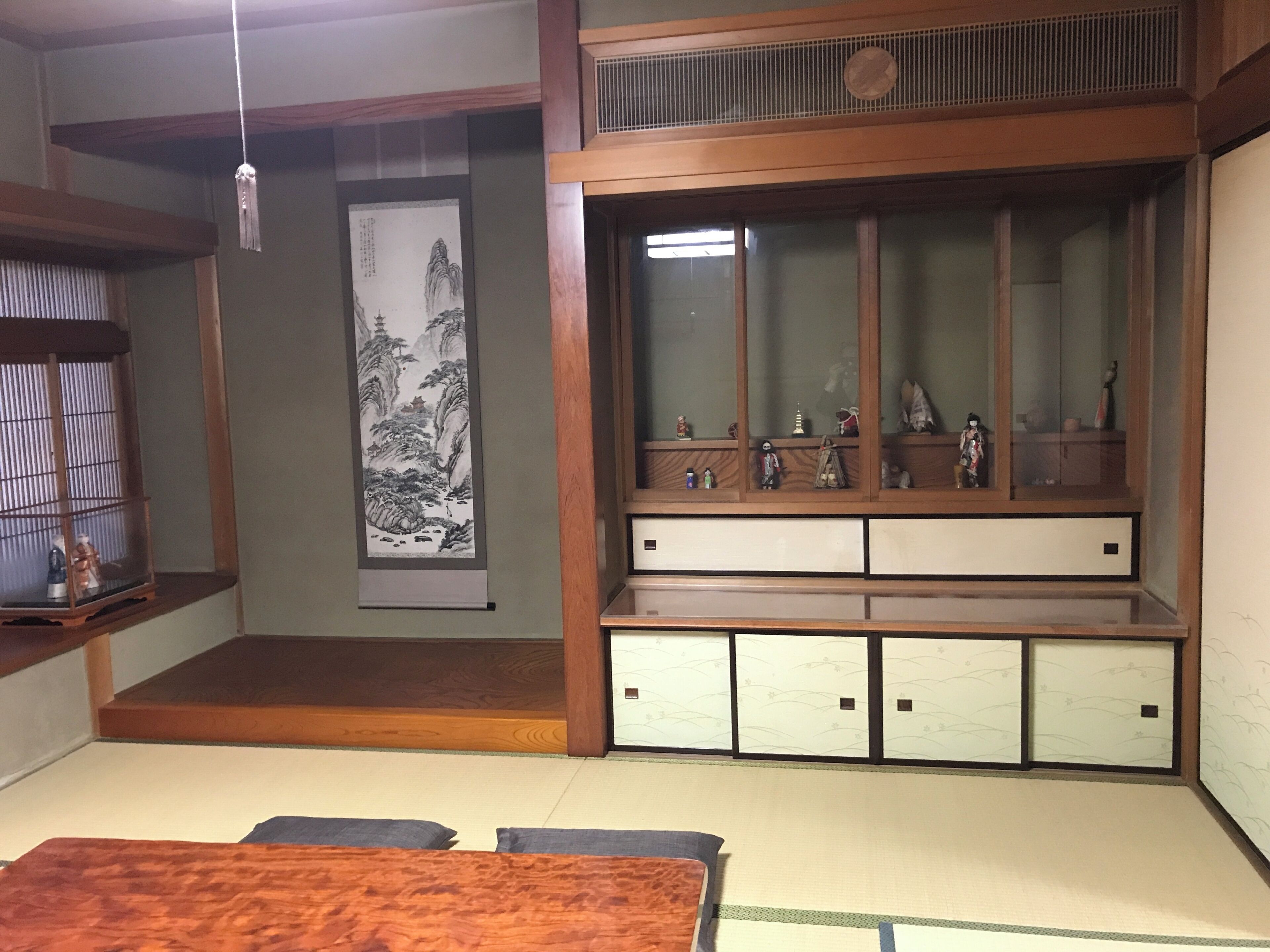 A traditional Japanese room with tatami flooring, a low wooden table, a shoji screen, and a sliding door with a hanging lantern.