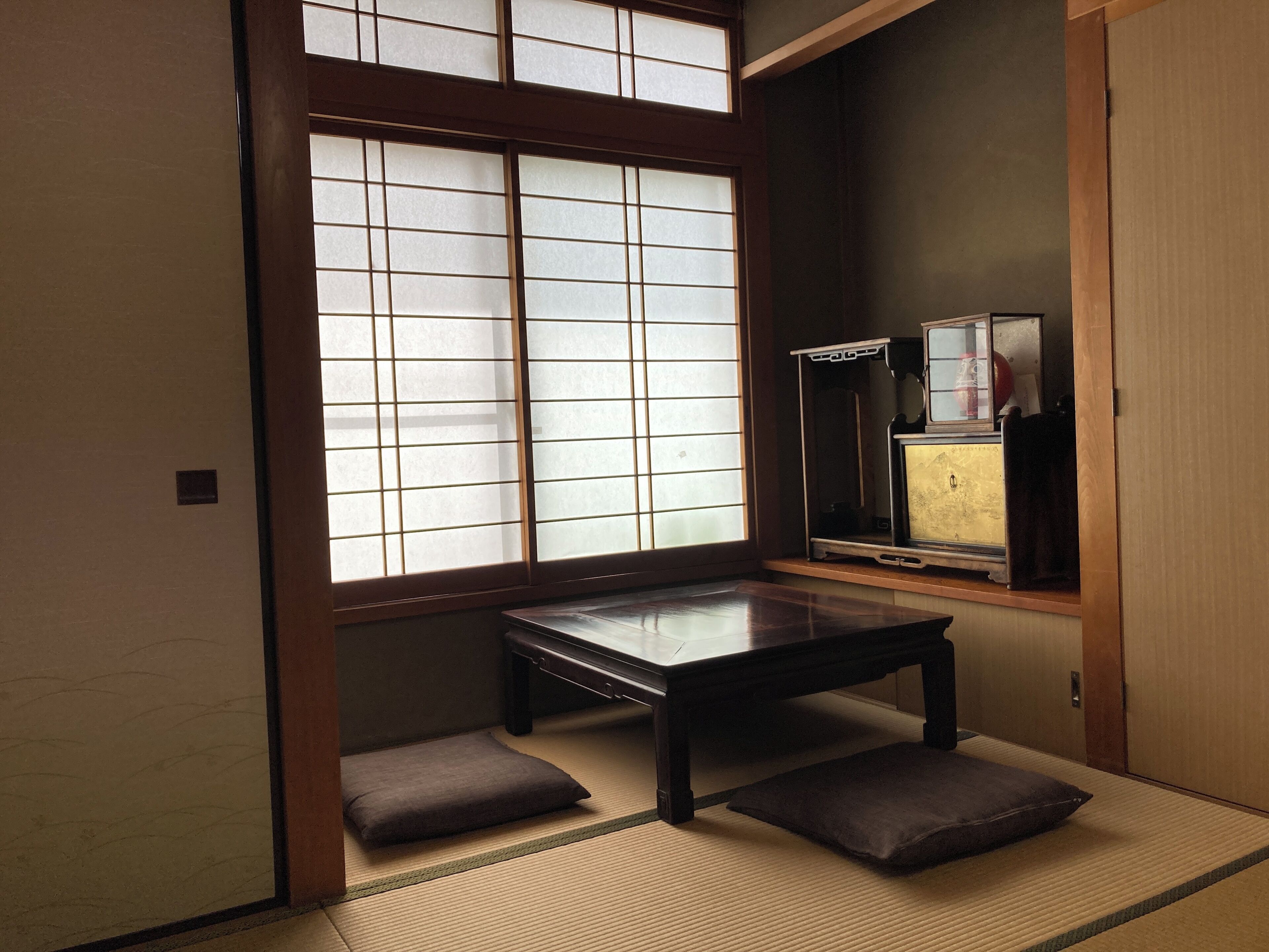 A traditional Japanese room with tatami flooring, a low wooden table, and sliding shoji doors.