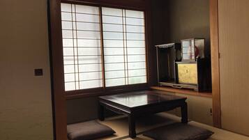 A traditional Japanese room with tatami flooring, a low wooden table, and sliding shoji doors.