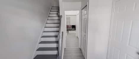 A staircase leading to a landing with a door on the right.