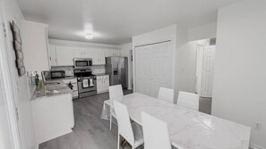 A compact kitchen with white cabinetry, a dining table with chairs, and a refrigerator. - Updated 3-bedroom2.5Bathtownhome nearMeritusCampus (Hagerstown)