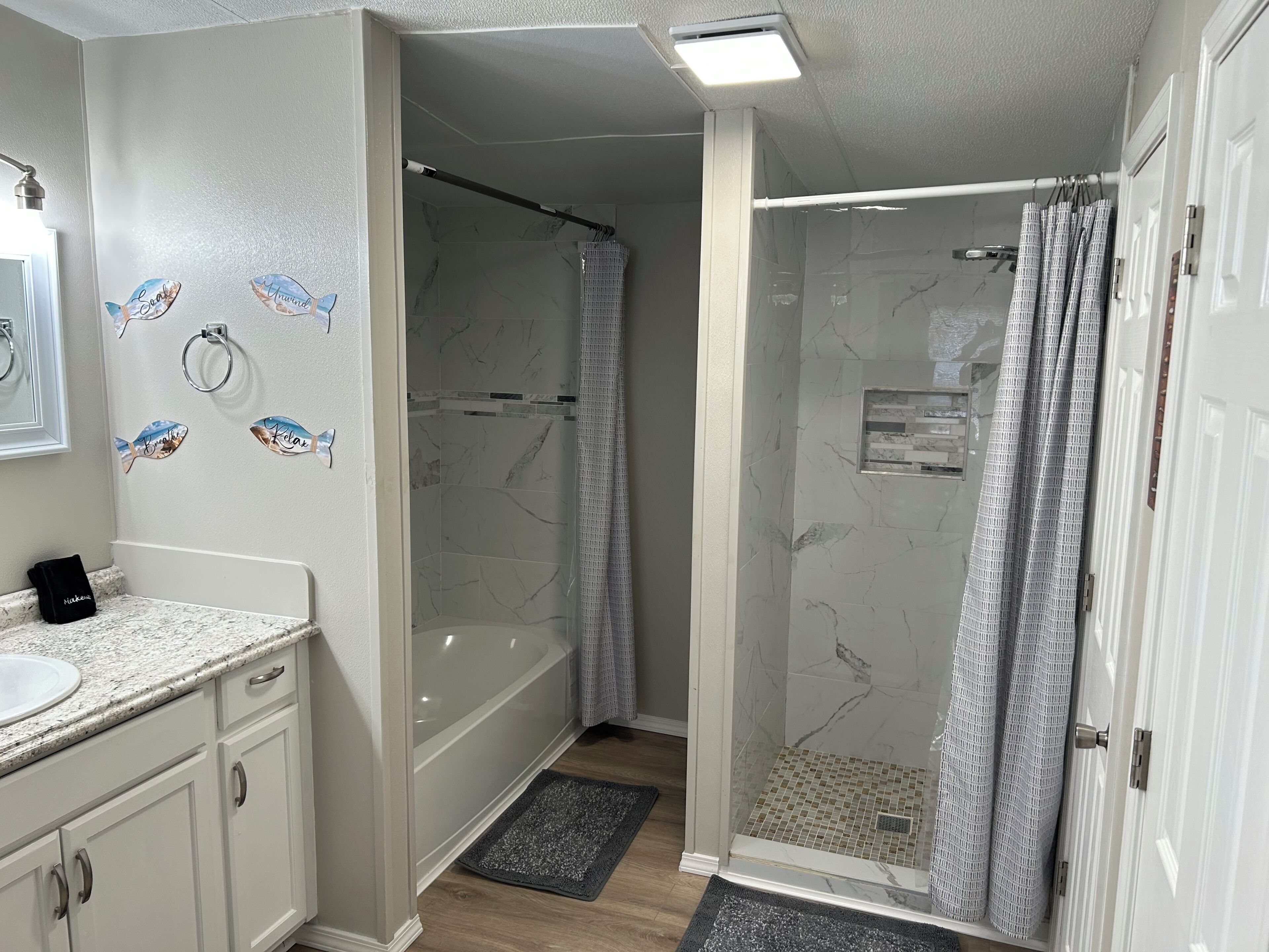 A bathroom with a shower, a sink, and a mirror.