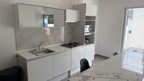 A modern kitchen with a sink, stove, cabinets, and a window. - Private home with a pool, 5 minutes from Six Flags Oaxtepec (Jardines de Tlayacapan)