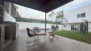 A covered patio with a pool, outdoor seating, and a hanging chair. - Private home with a pool, 5 minutes from Six Flags Oaxtepec (Jardines de Tlayacapan)