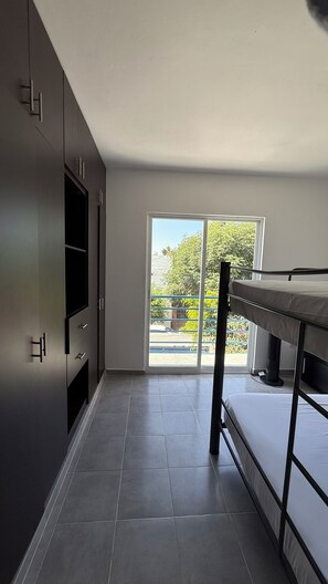 A modern kitchen with a built-in oven, a dining table, and a sliding glass door leading to an outdoor area. - Private home with a pool, 5 minutes from Six Flags Oaxtepec (Jardines de Tlayacapan)
