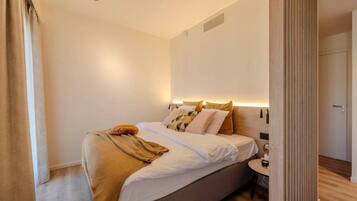 Ein Schlafzimmer mit Bett, Nachttisch und Beistelltisch.