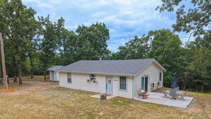 A single-story house with a front porch and a small patio area. - Charming outdoor getaway (Jay)
