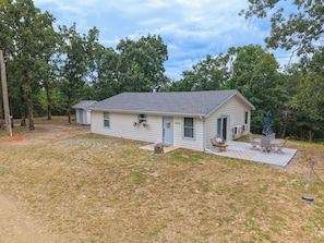A single-story house with a front porch and a small patio area. - Charming outdoor getaway (Jay)
