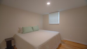 A bedroom with a bed, a window with blinds, and a ceiling light. - Charming outdoor getaway (Jay)