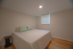 A bedroom with a bed, a window with blinds, and a ceiling light. - Charming outdoor getaway (Jay)