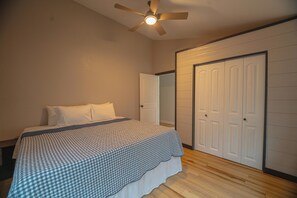 Ein Schlafzimmer mit einem Bett, einem Deckenventilator und einem Kleiderschrank.