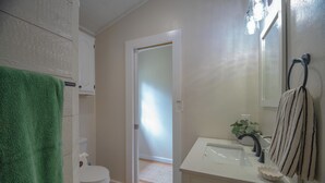 A bathroom with a toilet, sink, and towel rack. - Charming outdoor getaway (Jay)