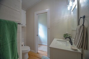 A bathroom with a toilet, sink, and towel rack. - Charming outdoor getaway (Jay)