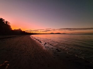 A beach with a clear sky and calm water. - HIBISCUS DELIGHTS @ APARTMENT 19 - a lovely apartment in the heart of town. (Port Douglas)