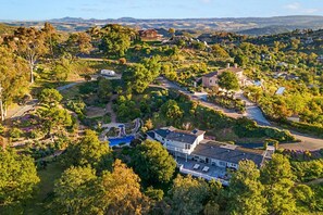 A residential area with multiple houses, a swimming pool, and a winding road.