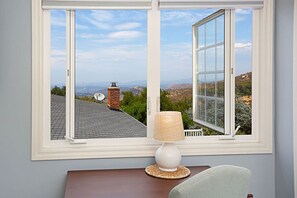 A room with a large window offering a view of a mountainous landscape.