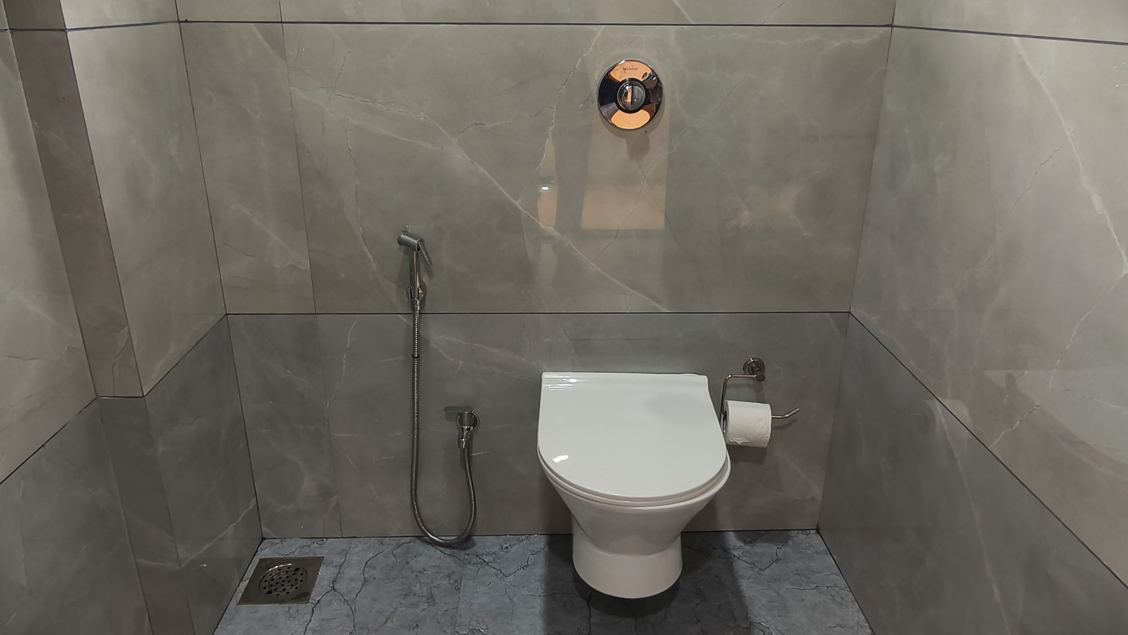 Un bagno moderno con un water, una doccia e un porta carta igienica.