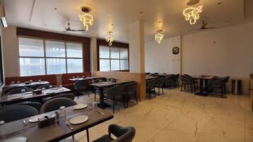 Un restaurante con varias mesas, sillas e iluminación moderna.