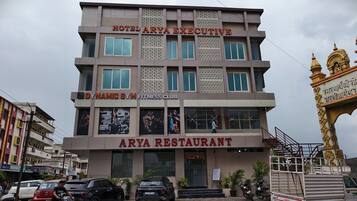 A multi-story building with a sign for Hotel Arya Executive, Dynamic Gym Fitness Club, and Arya Restaurant.
