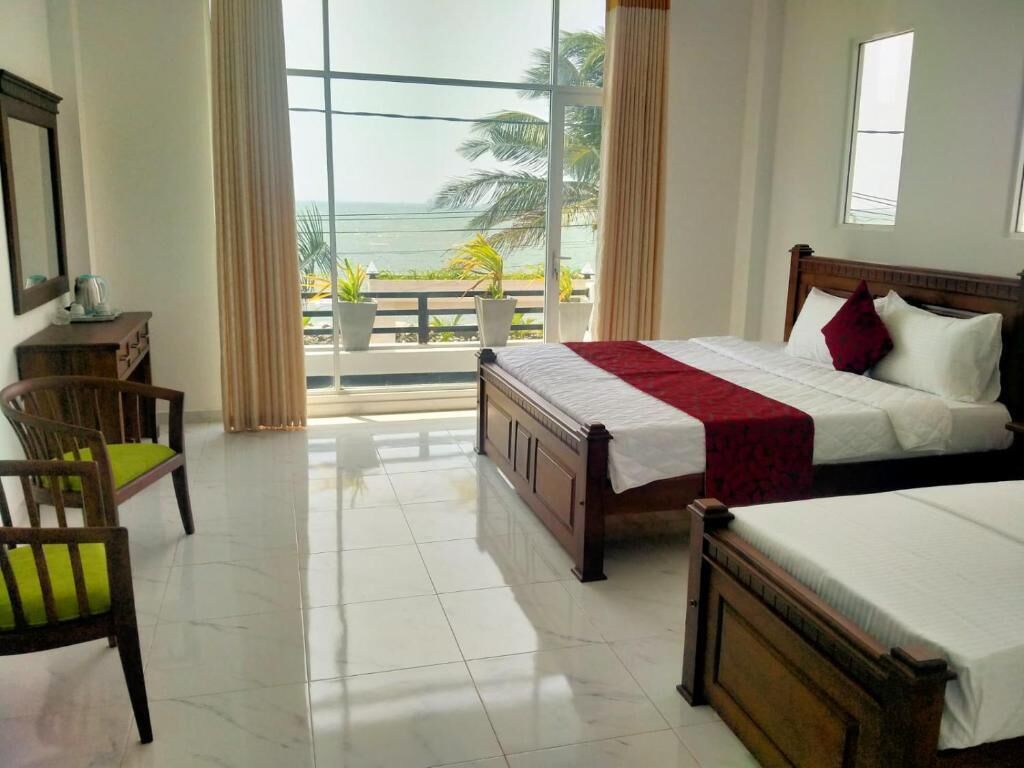 A hotel room with a large window, a bed, a chair, and a small table.