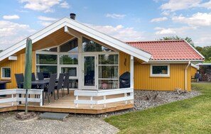 A wooden cabin with a deck, large windows, and a red-tiled roof. - Gorgeous home in Nysted with WiFi (Nysted)