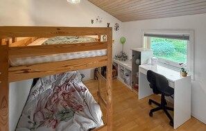 A bedroom with a bunk bed, a desk, and a window with a view of greenery. - Gorgeous home in Nysted with WiFi (Nysted)