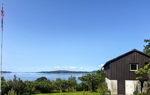 A coastal property with a wooden building, a flagpole, and a view of the sea. - 3 bedroom lovely home in Fister (Fister)